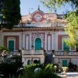 Ci appare con il suo delicato rosso pompeiano che si unisce al bianco degli ornamenti e al verde delle persiane